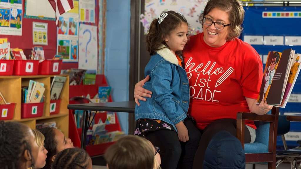 Blue Ridge Community College Elementary Education Residency Program student works with a young child reading a book in the classroom